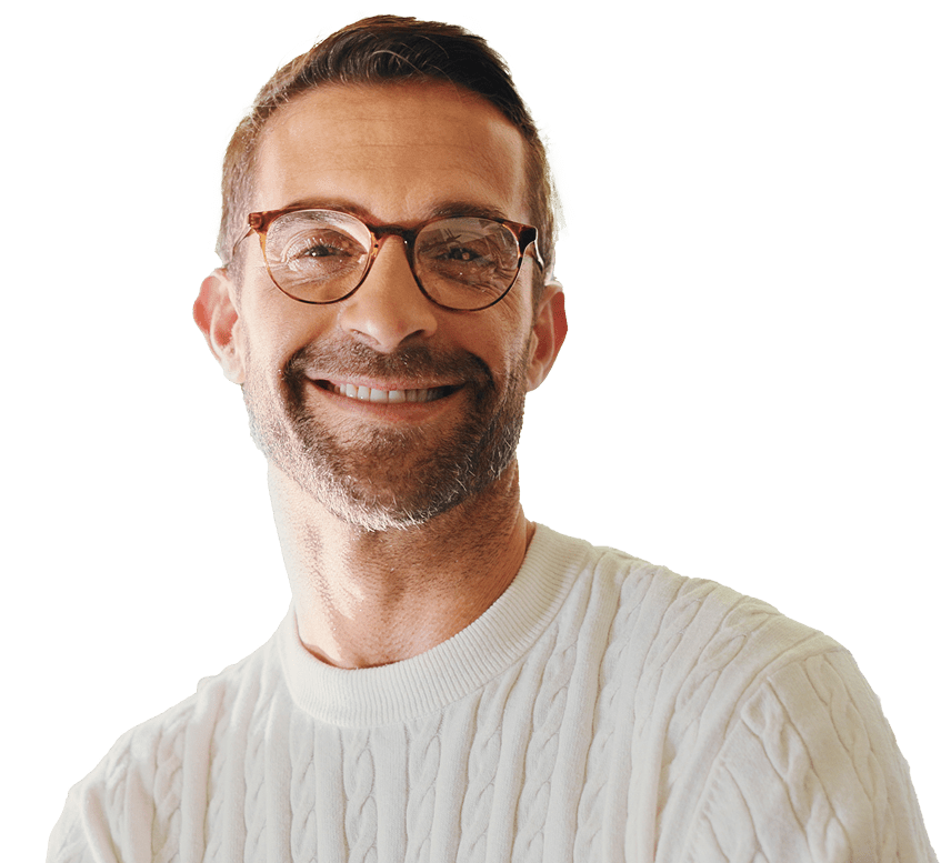Bild von einem lächelnden Mann mittleren Alters. Er trägt eine Brille und sieht den Nutzer direkt an.